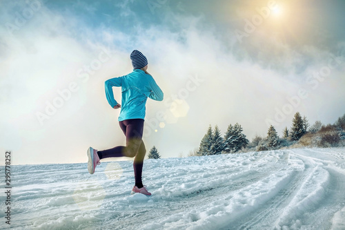 Fotomural Running woman. Runner on the snow in winter sunny day. Female fi