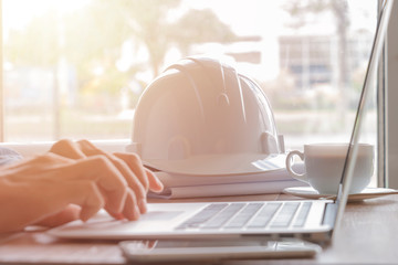 Architect man working with laptop and blueprints,engineer inspection in workplace for architectural plan,sketching a construction project ,selective focus,in the morning,Business concept