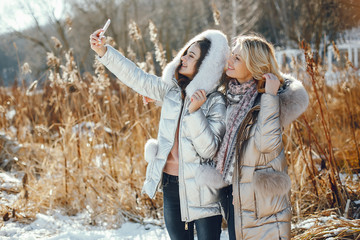 Wall Mural - young blonde mom with her grown up daughter in a winter park