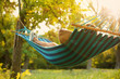 Leinwandbild Motiv Young man resting in comfortable hammock at green garden
