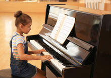 Cute Little Girl Playing Piano Indoors. Music Lesson