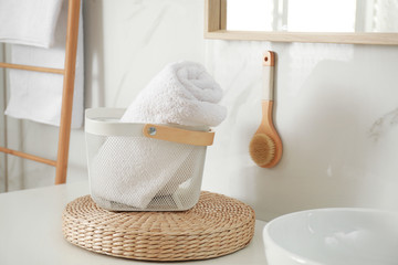 Poster - Basket with clean towel in modern bathroom interior