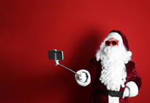Authentic Santa Claus Taking Selfie On Red Background
