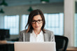© mavoimages - Focused businesswoman sitting at her desk working on a laptop
