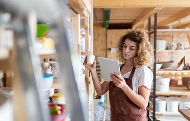 Wall Mural - Craftswoman with tablet computer in art studio 