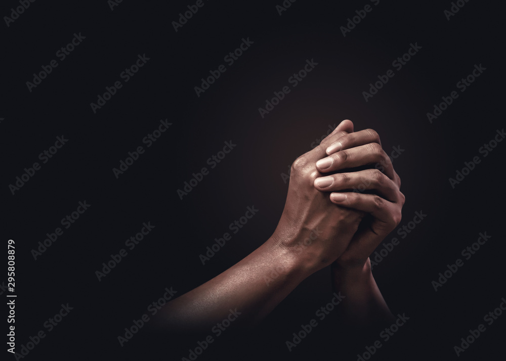 Praying hands with faith in religion and belief in God on dark background. Power of hope or love and devotion. - obrazy, fototapety, plakaty 