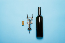 Bottle Of Wine And Corkscrew On A Blue Background. Concept Sommelier, Wine Tasting, Wine Accessories. Flat Lay, Top View