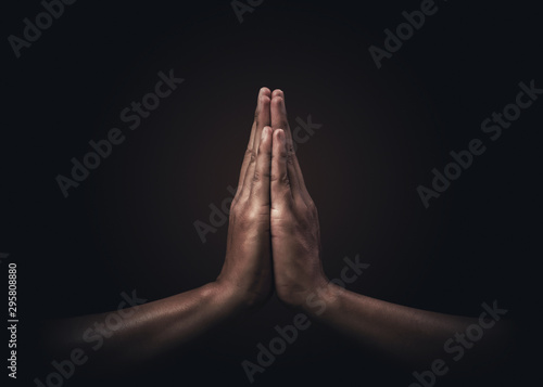 Fotomural Praying hands with faith in religion and belief in God on dark background