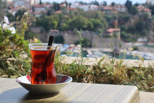 glass of turkish tea overlooking antalya old harbour
