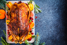 Christmas Baked Duck With Herbs And Fruits On Gray Plate, Blue Background, Top View.