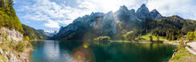 Famous Lake Gosau And Gosaukamm With Mount Dachstein. The Sun Is About To Hide Behind The High Peaks While Autumn Is About To Settle In With All The Vibrant Colors Around The Lake And Hills.