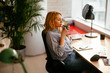 © JustLife - Young businesswoman drinking coffee in her office