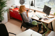 © JustLife - Young businesswoman drinking coffee in her office