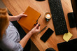 © JustLife - Top view of young businesswoman opening notebook