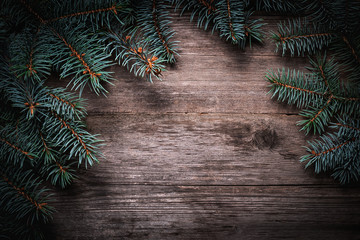 Wall Mural - Christmas green frame from fir branches on a vintage gray board background. Frame of fir branches. Christmas card blank.