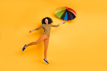 Sticker - Full length body size photo of wavy cheerful cute nice charming pretty girlfriend flying with umbrella wearing orange pants trousers footwear isolated over vivid yellow color background