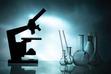 test tubes. beakers. flasks. beakers in the dark. a microscope next to the beakers. sale of laborato