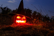 Spooky Halloween Pumpkin Jack-o-lantern In Witch Hat With Burning Candles In Scary Forest At Night