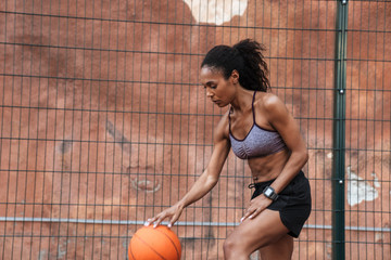 Poster - Attractive young african sportswoman playing basketball