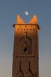 Moroccan village tower with moon framing the top spires
