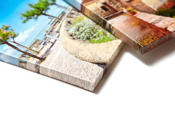 Canvas photo prints isolated on white background. Sample of gallery wrapping method of canvas stretching on stretcher bar. Side view of colorful photographs printed on glossy synthetic canvas closeup