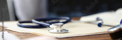 Fotografía Medical stethoscope head lying at paper document on table