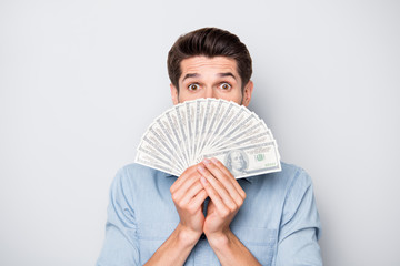 Poster - Photo of shocked funny cheerful funky guy hiding half of his face behind money he has earned out of successful way of freelancing isolated over grey color background