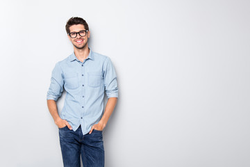 Fototapete - Photo of cheerful funky positive intelligent man smiling toothily holding hands in pockets isolated over grey color background
