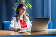 © khosrork - Portrait of crazy beautiful stylish brunette young woman in glasses sitting and looking at laptop display with crossed eyes funny face. indoor studio shot, cafe, office background.