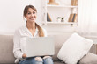 © Prostock-studio - Cheerful Lady Working On Laptop Sitting On Couch At Home