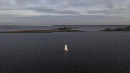 Wall Mural - 4k alone sailboat sailing across river. Aerial drone shot