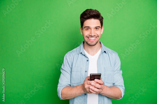 Fotomural Photo of cheerful brown haired handsome blogger browsing through his telephone l
