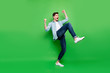 Full length body size turned photo of cheerful positive excited ecstatic man rejoicing with his victory at competitions isolated over green color vivid background