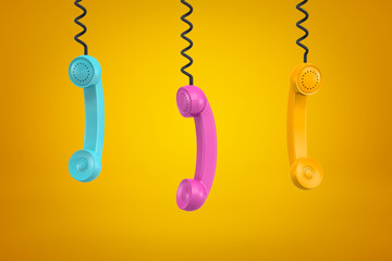 Wall Mural - 3d rendering of three colorful retro telephone receivers hanging on yellow background
