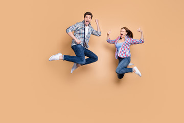 Sticker - Full length photo of two people crazy lady guy jumping high raising thumbs up celebrating successful win wear casual plaid jeans clothes isolated beige color background