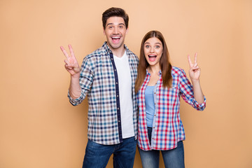 Canvas Print - Portrait of his he her she nice attractive lovely charming funky glad cheerful cheery couple wearing checked shirt showing v-sign embracing isolated over beige pastel color background