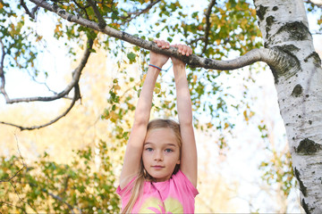 Wall Mural - Child brave cute girl climbing on tree