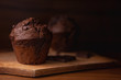 Chocolate muffins on a wooden chopping board, dark moody food photography