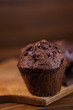 Chocolate muffins on a wooden chopping board close-up, dark moody food photography
