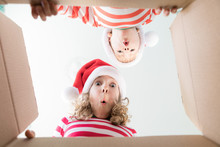 Surprised Children Unpack Christmas Gift Box