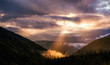 canvas print picture - Fairy landscape with dramatic sky and sunbeam in mountains