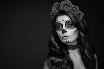 Portrait of a woman with sugar skull makeup over black background. Halloween costume and make-up. Black and white Portrait of Calavera Catrina