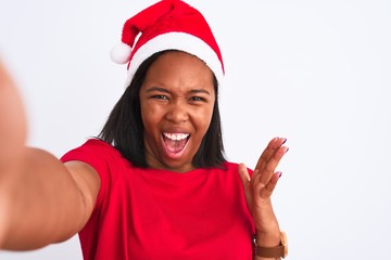 Young african american woman wearing christmas hat and taking a selfie over isolated background very happy and excited, winner expression celebrating victory screaming with big smile and raised hands