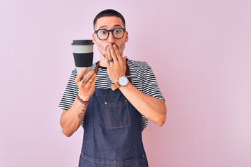 Wall Mural - Young handsome barista man wearing uniform over isolated background cover mouth with hand shocked with shame for mistake, expression of fear, scared in silence, secret concept