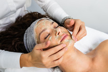 Beautiful Woman Receiving Natural Green Peel Facial Mask With Rejuvenating Effects In Spa Beauty Salon.