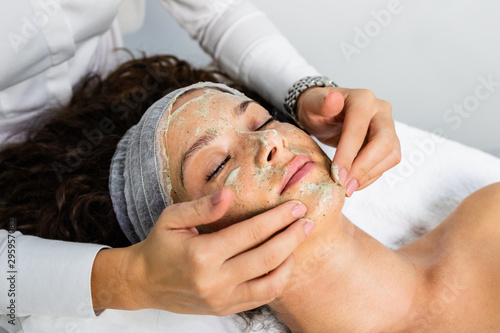 Fotografía Beautiful woman receiving natural green peel facial mask with rejuvenating effects in spa beauty salon