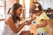 © Krakenimages.com - Young beautiful teacher and toddler playing with small building blocks toy at kindergarten