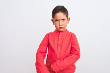 Poster - Beautiful kid boy wearing elegant red shirt standing over isolated white background skeptic and nervous, disapproving expression on face with crossed arms. Negative person.