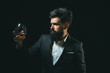 © Volodymyr - Drinking whiskey or brandy or cognac. Elegant and stylish man in classical wear holding glass with wiskey in hand. Stylish rich man holding a glass of old whisky.