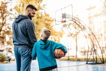 Father And His Son Enjoying Together On Basketball Court.